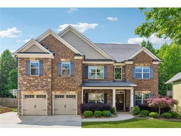Beautiful two-story brick home featuring a two-car garage, manicured lawn, and inviting front porch at 2358 Well Springs Dr, Buford, GA 30519