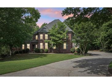 Charming two-story brick home with lush landscaping and a circular driveway at 3235 Munsey Ct, Cumming, GA 30041
