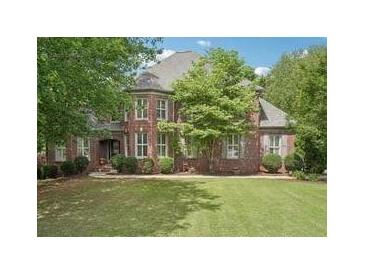 Charming brick home with lush green lawn and mature trees in a desirable neighborhood at 3235 Munsey Ct, Cumming, GA 30041