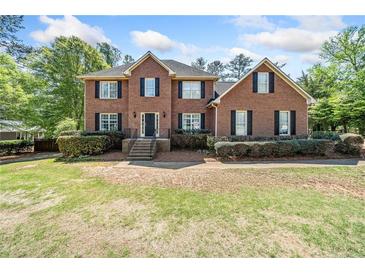 Traditional two-story brick home featuring black shutters and a well-manicured lawn at 5247 Hayden Farms Dr, Powder Springs, GA 30127