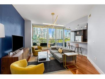 Bright living room with a blue accent wall, comfortable seating, and a view of the city skyline at 1080 Peachtree Ne St # 608, Atlanta, GA 30309