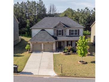 Charming two-story home featuring a two-car garage, well-maintained lawn, and attractive stone and brick accents at 4750 Sabino Bnd, Cumming, GA 30040