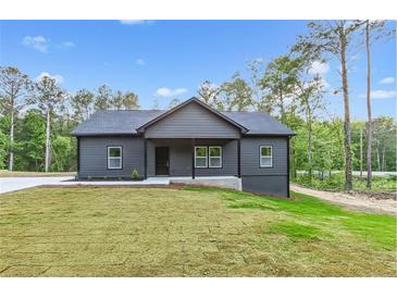 Charming single-story home with a covered porch and freshly landscaped front yard at 60 Wheeler Lake Path, Dallas, GA 30157