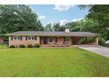 Charming brick ranch-style home with a well-manicured lawn and covered carport, creating curb appeal at 4125 Hickory Dr, Powder Springs, GA 30127