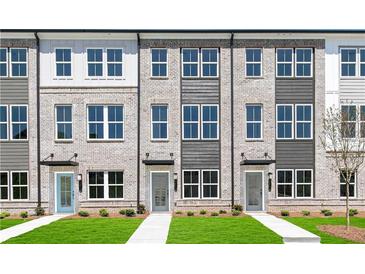 Charming townhome exterior with gray brick, modern accents, and a well-manicured lawn at 2670 Brookview Nw Ln, Atlanta, GA 30318
