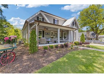 Charming gray two-story home featuring a covered front porch, manicured landscaping, and inviting curb appeal at 527 Main St, Suwanee, GA 30024