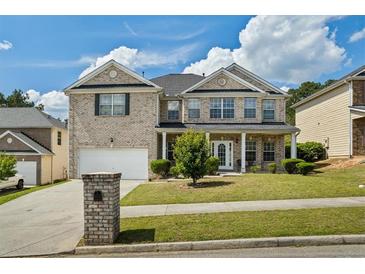 Beautiful two-story brick home featuring a manicured front yard and inviting entrance at 7328 Vigo Dr, Lithonia, GA 30058
