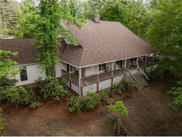 Charming home featuring a cozy, covered porch perfect for enjoying the serene wooded surroundings at 8315 Nicholson Rd, Cumming, GA 30028
