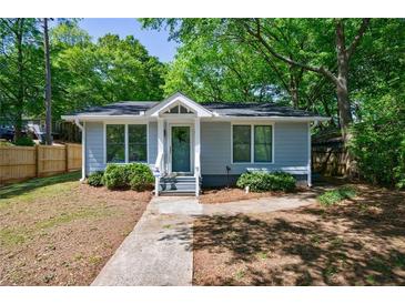Charming single-story home features a beautifully landscaped front yard with mature trees at 1314 Arkwright Se Pl, Atlanta, GA 30317