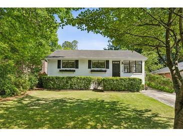 Charming single-story home with a well-manicured lawn, lush greenery, and painted white brick at 2129 Arlington Ne Ave, Atlanta, GA 30324