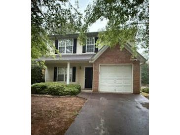 Two-story home featuring a brick accent, attached garage, and well-maintained landscaping at 4752 Browns Mill Ferry Rd, Lithonia, GA 30038