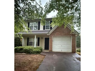 Charming two-story home featuring a brick accent wall and attached one car garage at 4752 Browns Mill Ferry Rd, Lithonia, GA 30038