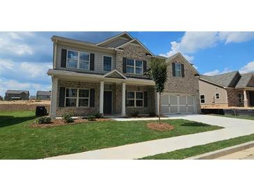 Charming two-story home with brick facade, landscaped yard, and a two-car garage at 1107 Kingston Hill Dr, Loganville, GA 30052