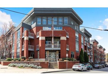 Modern brick condo building featuring multi-level balconies and manicured landscaping at Centennial Station at 89 Mangum St # 210, Atlanta, GA 30313