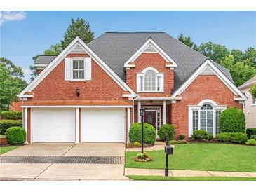 Charming brick home featuring a two-car garage, manicured lawn, and mature trees offering curb appeal at 350 Declaire Ne Way, Marietta, GA 30067