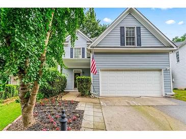 Charming two-story home with a two-car garage, an American flag, and a well-manicured front yard at 2865 Winter Rose Ct, Dunwoody, GA 30360