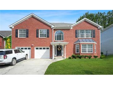 Charming red brick two-story home featuring an attached garage and a well-manicured front lawn at 4125 Fallbrook Dr, Duluth, GA 30096