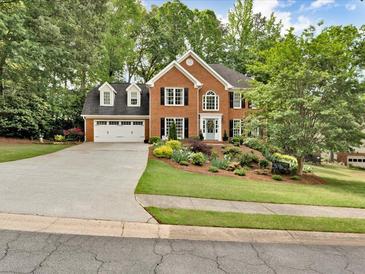 Charming brick home with a well-manicured lawn, mature trees and attached two car garage at 5625 Brookstone Nw Dr, Acworth, GA 30101