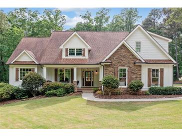 Charming home featuring a stone facade, wood shutters, and a covered front porch at 1825 Epperson Rd, Canton, GA 30115