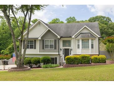 Charming two-story home with manicured lawn, lovely shrubbery, and a mix of vinyl and brick exterior at 2180 Oakpointe Ct, Buford, GA 30519
