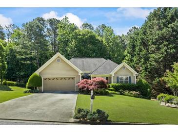 Charming home featuring a well-manicured lawn, mature trees and attached garage at 2191 Flowering Dr, Grayson, GA 30017