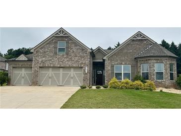 Charming brick home with a three-car garage, well-manicured lawn and lovely landscaping at 3925 Sierra Knolls Ct, Cumming, GA 30040