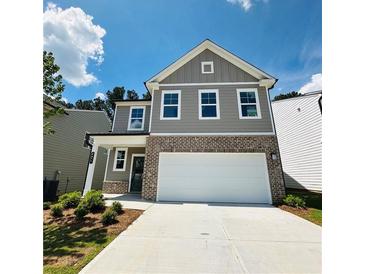 Beautiful two-story home featuring a two-car garage, a brick facade and gray siding at 4495 Buttonwood Ln, Lilburn, GA 30047