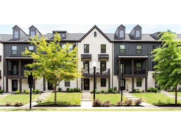 Charming townhomes boast a mix of white brick and gray siding, complemented by well-manicured lawns at 135 Climbing Ivy Cir, Fayetteville, GA 30214