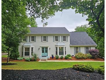 Charming two-story home with a landscaped front yard, gray shutters, and a bright blue front door at 1885 Dayron Trce, Marietta, GA 30062