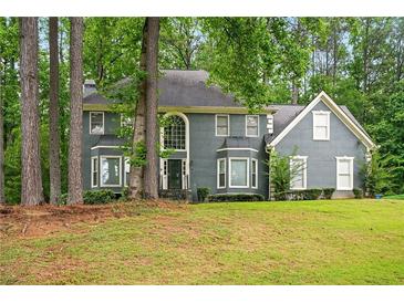 Charming two-story home featuring a well-manicured lawn, mature trees, and a classic facade at 1256 Spring Park Sw Dr, Atlanta, GA 30311