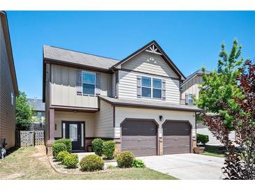 Charming two-story home with a two-car garage, manicured landscaping, and a welcoming front porch at 2753 Trebek Ct, Mcdonough, GA 30253