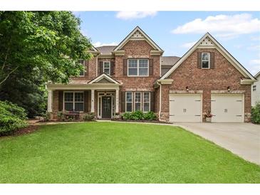 Charming two-story brick home with a lush green lawn and two-car garage at 2955 Pleasant Valley Trl, Cumming, GA 30028