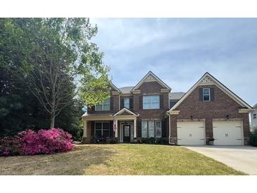 Charming two-story brick home with a well-manicured lawn and attached two-car garage at 2955 Pleasant Valley Trl, Cumming, GA 30028