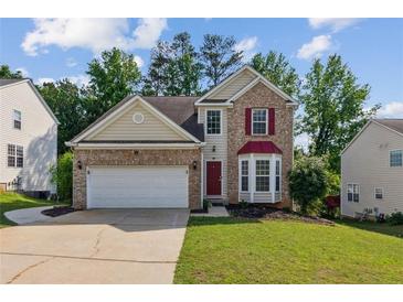 Charming two-story home with brick and siding, a red door, and a well-manicured lawn at 1224 Everwood Sw Dr, Marietta, GA 30008