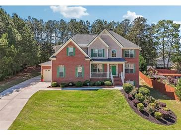 Charming brick home with green shutters, a front porch, and a beautifully landscaped yard at 1829 Alcovy Shoals Blf, Lawrenceville, GA 30045