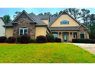 Charming home with a combination of stone and siding, complemented by a lush green lawn and mature trees at 4060 San Marco Way, Douglasville, GA 30135