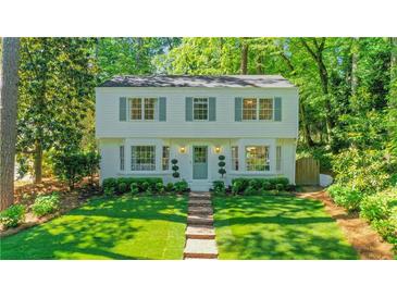 Charming two-story home with brick walkway and manicured lawn surrounded by mature trees at 770 Wellesley Nw Dr, Atlanta, GA 30305