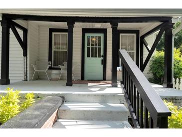 Inviting front porch with a striking teal door and ample seating area at 1608 Carroll Nw Dr, Atlanta, GA 30318