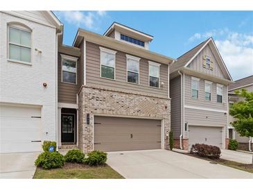 Charming townhome features a two-car garage, a mix of brick and siding, and manicured landscaping at 1227 Herty Dr, Marietta, GA 30062