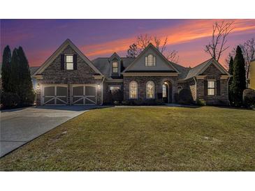 Charming brick home with a two-car garage and manicured lawn, beautifully lit at dusk at 448 Hanover Drive, Villa Rica, GA 30180