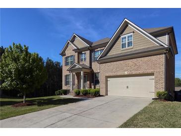 Charming two-story brick home with manicured lawn, a two-car garage and inviting curb appeal at 3204 Ivy Farm Path, Buford, GA 30519