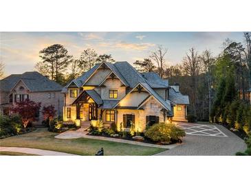 Beautiful exterior of a well-maintained two-story home with lush landscaping and stone accents at dusk at 1125 Lake Shore Overlook, Alpharetta, GA 30005