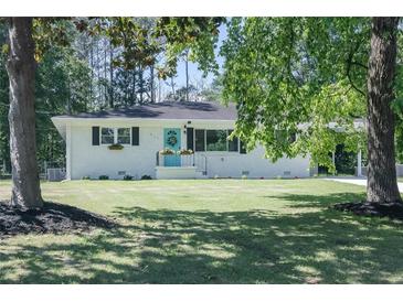 Charming single-story home featuring a well-maintained lawn and delightful blue front door at 317 Community Sw Dr, Mableton, GA 30126