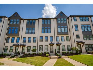 Charming townhome featuring a light brick facade, multiple windows and well maintained landscaping at 6790 Encore Blvd, Sandy Springs, GA 30328