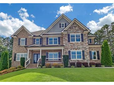 Beautiful two-story home featuring brick and stone facade, manicured lawn, and dark window shutters at 859 Heritage Lake Way, Grayson, GA 30017