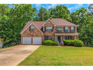 Charming brick home featuring a two-car garage and a well-manicured front lawn at 11354 Conner Ct, Hampton, GA 30228