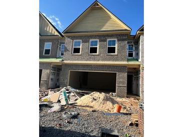 New construction townhome featuring a brick facade and an attached two-car garage at 3106 Marbella Cir # 3, Kennesaw, GA 30152