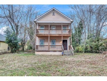 Two-story tan home with double front porches and a small, grassy front yard at 392 Vine St, Atlanta, GA 30314