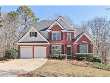 Beautiful two-story home boasts a brick facade, two-car garage, and meticulously maintained landscaping at 5034 Hickory Hills Dr, Woodstock, GA 30188