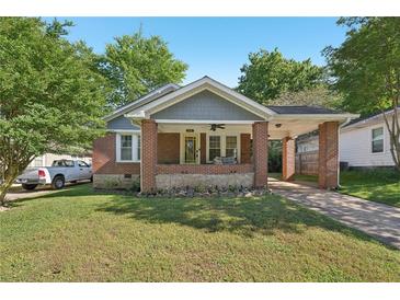 Charming brick home with a covered front porch and a well-maintained lawn at 1841 Thompson Ave, Atlanta, GA 30344